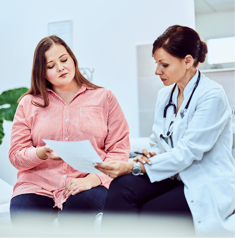 A doctor consulting with a patient, reviewing medical documents.